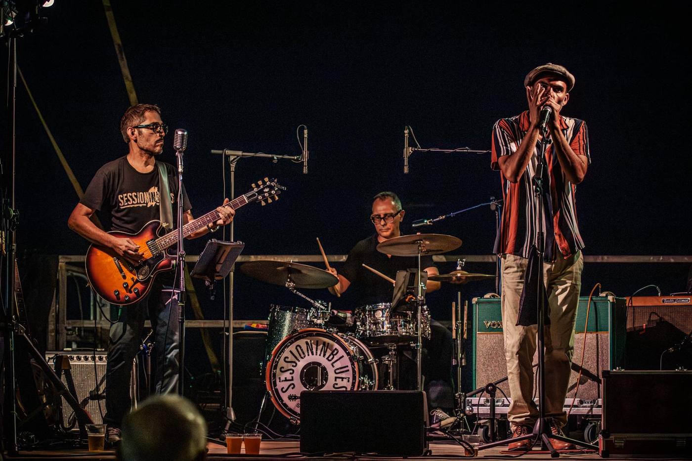 Marco Farris on harmonica on stage with guitar and drums