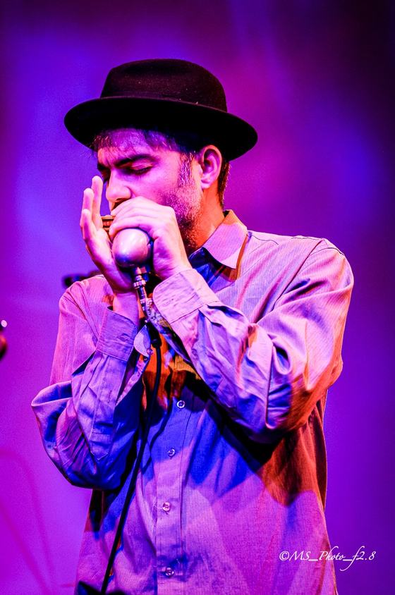 Marco Farris playing harmonica with cupped hands