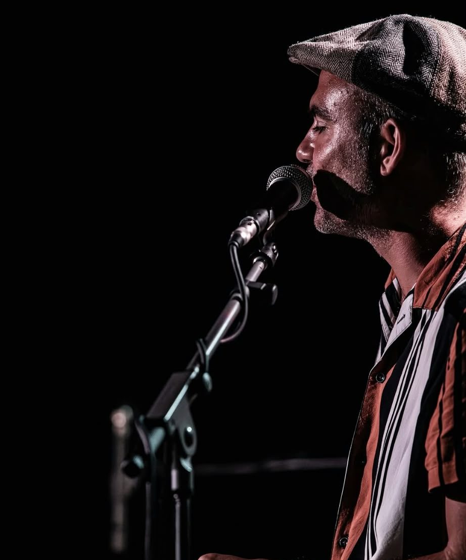 Marco Farris singing into a microphone on stage
